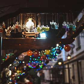 Festive ornaments hang down from a stall at a Christmas market