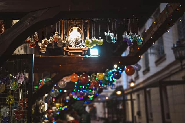 Festive ornaments hang down from a stall at a Christmas market
