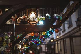 Festive ornaments hang down from a stall at a Christmas market