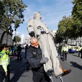 Police officers remove an oil-splattered statue of British Prime Minister Boris Johnson made by artist Hugo Farmer and installed by Greenpeace activists at Downing Street