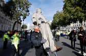 Police officers remove an oil-splattered statue of British Prime Minister Boris Johnson made by artist Hugo Farmer and installed by Greenpeace activists at Downing Street