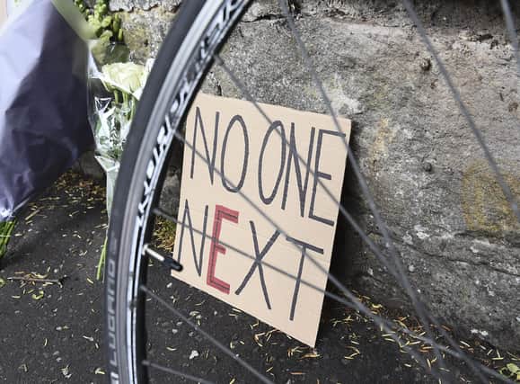 E for Enough: A sign left among flowers for cyclist James Harrison who died in a collision with a van (Picture: Lisa Ferguson)