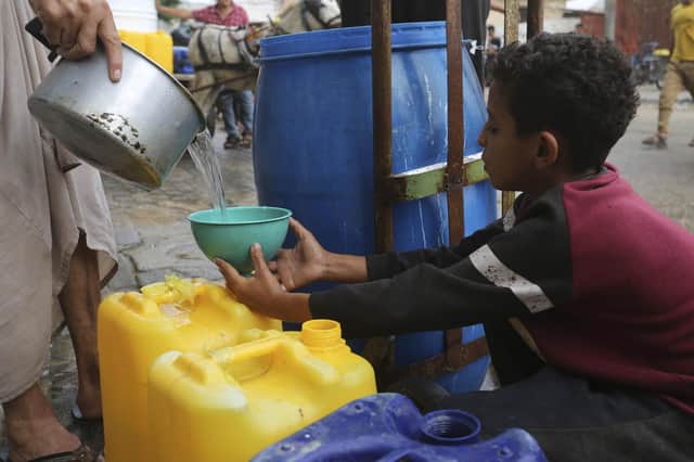 A Palestinian boy fills a cup with drinking water during the ongoing Israeli bombardment of the Gaza Strip in Rafah at the weekend