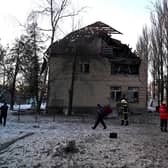 Rescuers and police experts examine remains of a drone following a strike on an administrative building in the Ukrainian capital Kyiv.