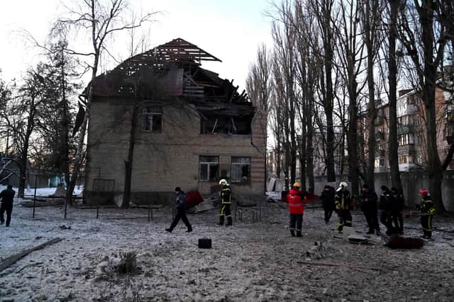 Rescuers and police experts examine remains of a drone following a strike on an administrative building in the Ukrainian capital Kyiv.