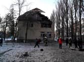 Rescuers and police experts examine remains of a drone following a strike on an administrative building in the Ukrainian capital Kyiv.