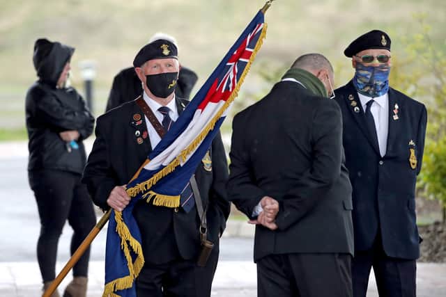A retired submariner carries a flag at Stirling Crematorium for the funeral of cyclist Anthony Parsons, whose body was found three years after he vanished (picture credit: Andrew Milligan/PA Wire).