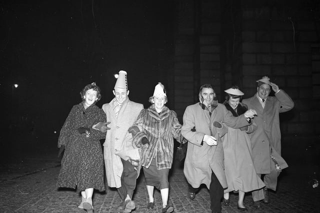 Six American visitors dance down the High Street during Hogmanay celebrations in 1955.