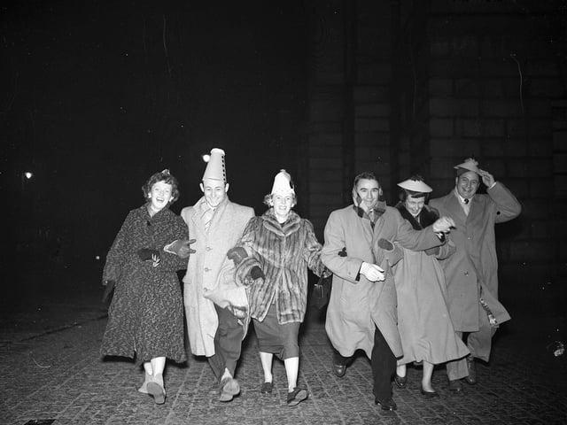 Six American visitors dance down the High Street during Hogmanay celebrations in 1955.