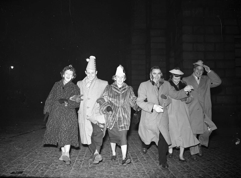 Six American visitors dance down the High Street during Hogmanay celebrations in 1955.