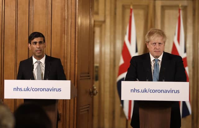Britain's Chancellor Rishi Sunak, left, is flanked by British Prime Minister Boris Johnson as he pledged new support for British businesses. Picture: AP Photo/Matt Dunham