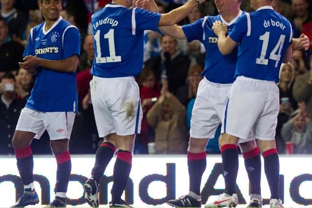 Giovanni van Bronckhorst (left) celebrates with Brian Laudrup, Ally McCoist and Ronald de Boer after setting up the only goal of the game for Rangers Legends - scored by McCoist - against AC Milan Glorie at Ibrox in March 2012. (Photo by Craig Watson/SNS Group).