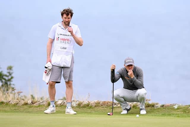 Stand-in caddie Michael MacDougall looks on as David Law lines up a putt on the 17th hole at Fairmont St Andrews. Picture: Ross Kinnaird/Getty Images.