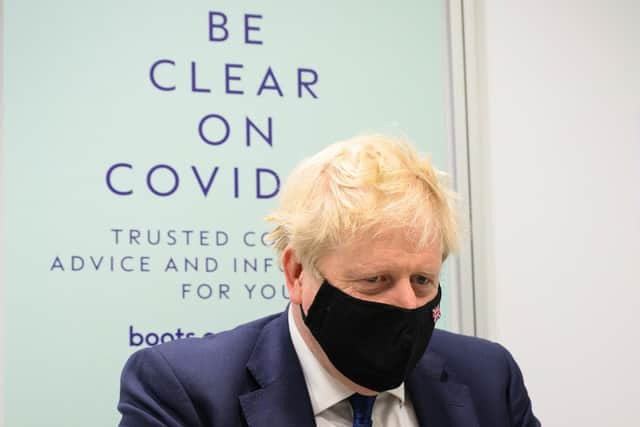 Prime Minister Boris Johnson prepares to watch a man receive his Covid-19 booster jab as he makes a constituency visit to a Boots pharmacy on in Uxbridge. Picture: Leon Neal/Getty Images