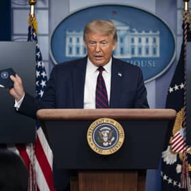 President Donald Trump holds a mask as he speaks during a news conference at the White House, Tuesday, July 21, 2020, in Washington. (AP Photo/Evan Vucci).
