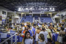 Evacuees sit inside a stadium following their evacuation during a forest fire on the island of Rhodes