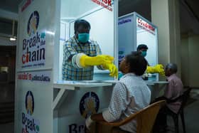 Medical staff collect samples from people at a Walk-In Sample Kiosk (WISK) to test for Covid at the Ernakulam Medical College in Kerala (Picture: Arun Chandrabose/AFP via Getty Images)