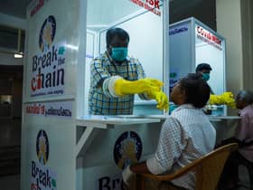 Medical staff collect samples from people at a Walk-In Sample Kiosk (WISK) to test for Covid at the Ernakulam Medical College in Kerala (Picture: Arun Chandrabose/AFP via Getty Images)
