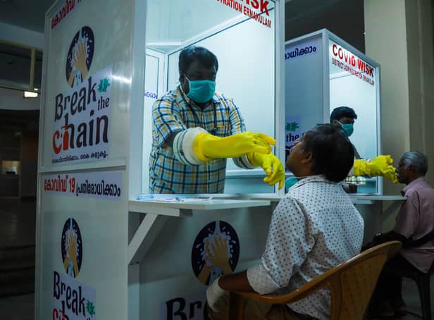 Medical staff collect samples from people at a Walk-In Sample Kiosk (WISK) to test for Covid at the Ernakulam Medical College in Kerala (Picture: Arun Chandrabose/AFP via Getty Images)