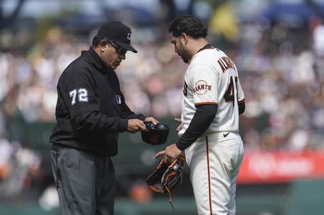 San Francisco Giants pitcher Jose Alvarez, right, has his cap inspected by umpire Alfonso Marquez. Picture: Jeff Chiu/AP