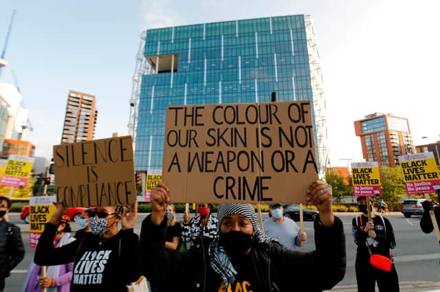 Black Lives Matter protesters hold up placards as they gather outside the American Embassy in London in September last year as a trial hearing for four police officers charged with the murder of George Floyd took place in the US (Picture: Tolga Akmen/AFP via Getty Images)
