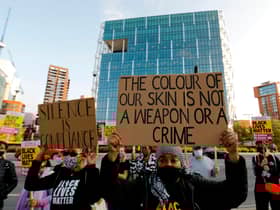 Black Lives Matter protesters hold up placards as they gather outside the American Embassy in London in September last year as a trial hearing for four police officers charged with the murder of George Floyd took place in the US (Picture: Tolga Akmen/AFP via Getty Images)