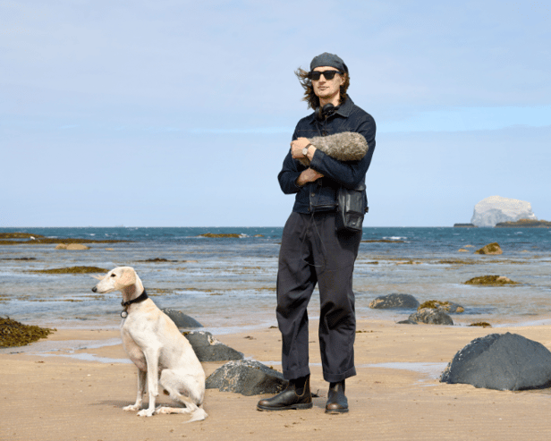 Erland Cooper at North Berwick beach with his dog Mirage, the Bass Rock in the background