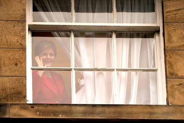 First Minister Nicola Sturgeon waves to members of the public outside Bute House in Edinburgh after she announced during a press conference that she will stand down as First Minister for Scotland after eight years