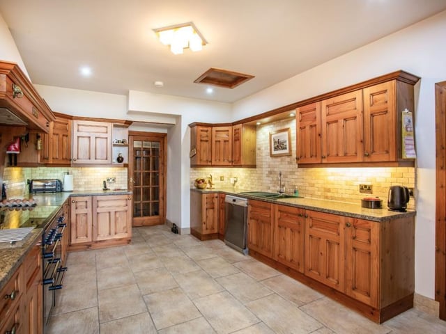 Kitchen with a range of wall and base units and modern integrated appliances.