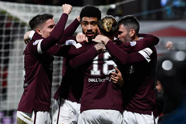 Hearts players mob Ginnelly after he scored his second goal.