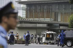 Police officers work near a vehicle, center, which was stuck against a barricade near the prime minister's office, background, in Tokyo (Pic: Kyodo News via AP)