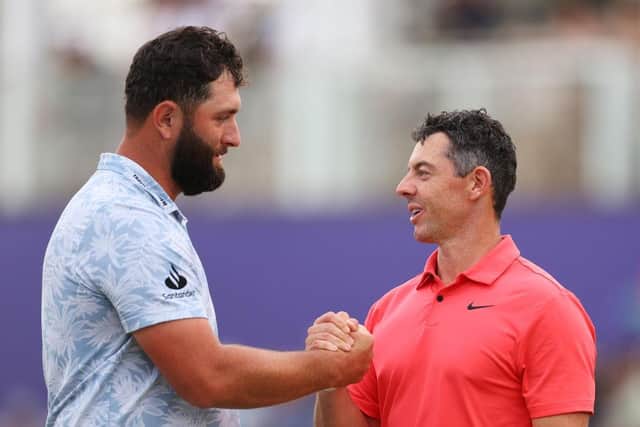 Jon Rahm and Rory McIlroy shake hands on the 18th green following their round in Dubai. Picture: Andrew Redington/Getty Images.