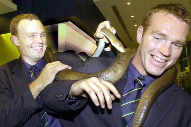 Stuart Grimes (left) and Andrew Mower get a close look at an Australian Olive Python at a reception ahead of their 2003 World Cup game against Japan in Townsville.