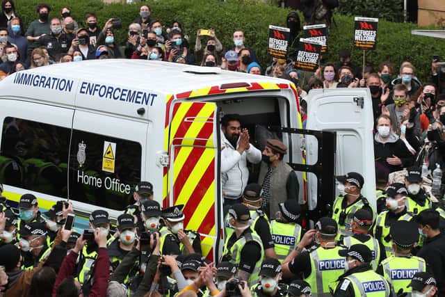 One of two men are released from the back of an Immigration Enforcement van accompanied by Mohammad Asif, director of the Afghan Human Rights Foundation, in Kenmure Street, Glasgow which is surrounded by protesters.