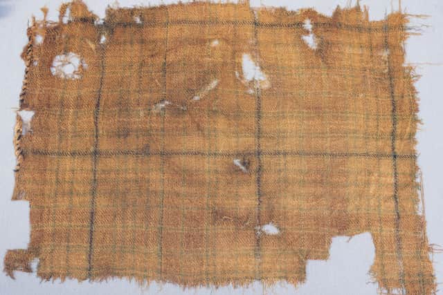 John McLeish, chair of the Scottish Tartans authority, V&A Dundee curator James Wylie and tartan historian Peter MacDonald have a close look at the Glen Affric tartan. Picture: Alan Richardson