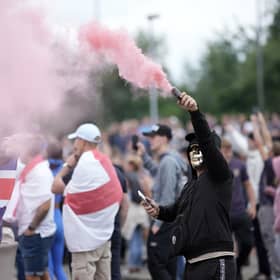 An anti-migration protester brandishes a flare during a riot outside of the Holiday Inn Express in Rotherham (Picture: Christopher Furlong/Getty Images)