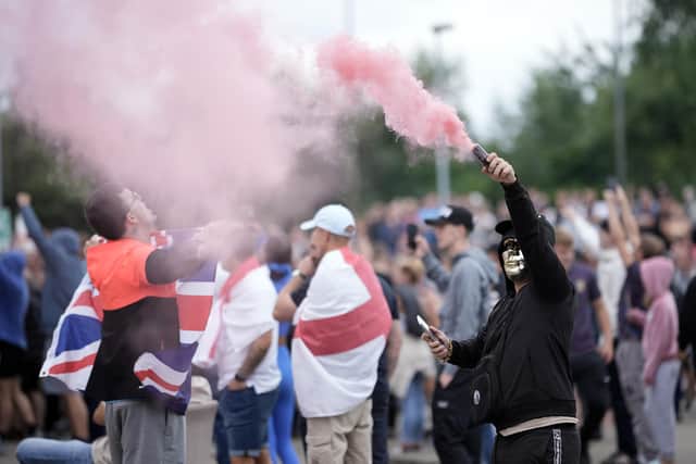 An anti-migration protester brandishes a flare during a riot outside of the Holiday Inn Express in Rotherham (Picture: Christopher Furlong/Getty Images)