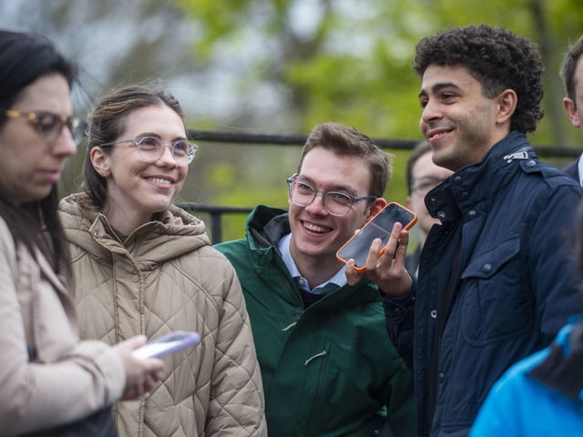 Members of the public listen to Humza Yousaf's resignation statement on their phones as he quits as Scotland's First Minister. Picture: Lisa Ferguson