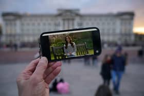 A person watches an announcement on a smart phone outside Buckingham Palace by the Princess of Wales, who has revealed she is undergoing chemotherapy treatment for cancer.. Photo: Yui Mok/PA Wire