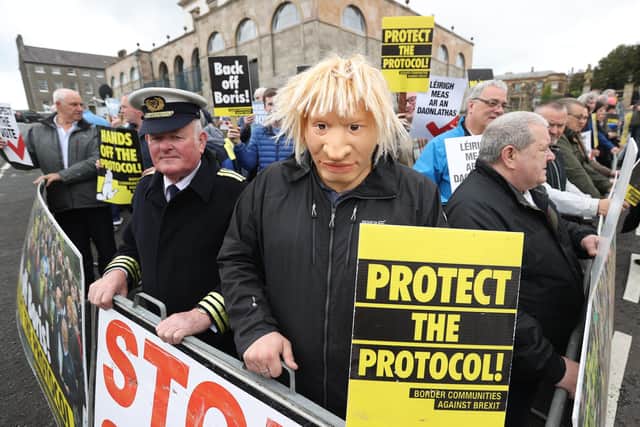 A man dressed as a customs officer and another dressed as Boris Johnson with protesters from Border Communities Against Brexit outside Hillsborough Castle