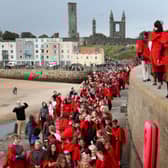 New students at the University of St Andrews take part in the traditional Pier Walk along the harbour walls of St Andrews before the start of the new academic year.