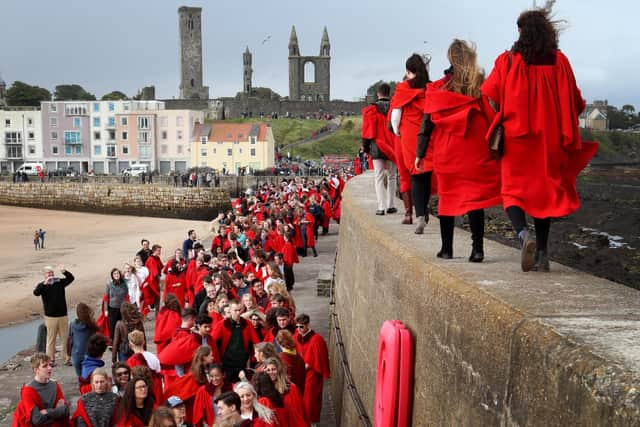 New students at the University of St Andrews take part in the traditional Pier Walk along the harbour walls of St Andrews before the start of the new academic year.