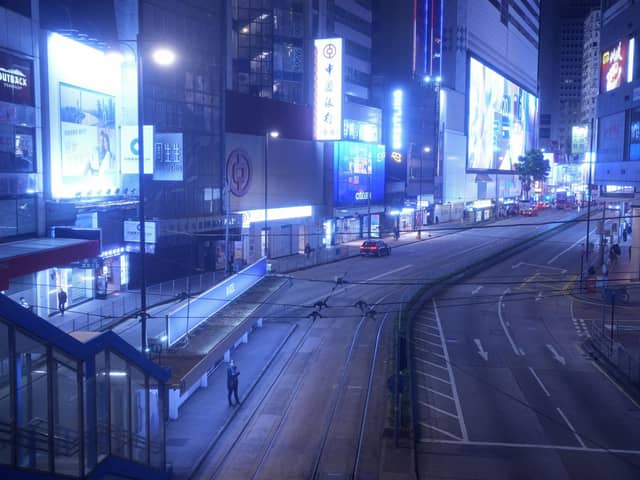 A woman stands on an empty street usually packed with shoppers in Causeway Bay, a famous shopping district in Hong Kong