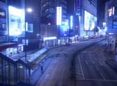A woman stands on an empty street usually packed with shoppers in Causeway Bay, a famous shopping district in Hong Kong