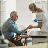 A man receives a blood test at home from a nurse