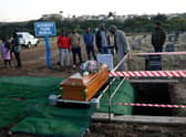 People stand near the coffin of Thembinkosi Silwane during his burial at Heaven Hills Cemetry in East London after he and 20 others, mostly teens, died in unclear circumstances at a township tavern last month, in an incident that shocked South Africa.