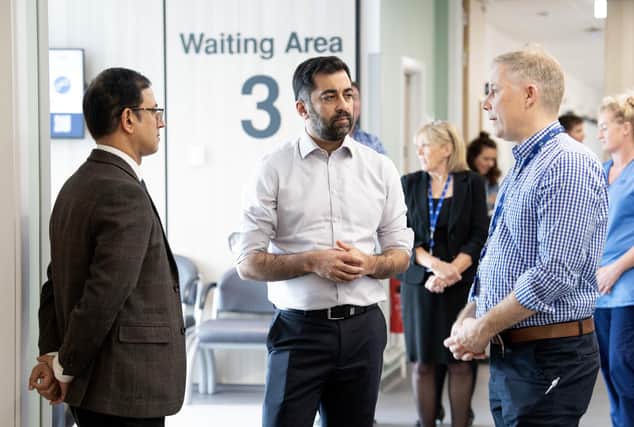 Humza Yousaf (centre) alongside Consultant Orthopedic Surgeon Andy Ballantyne (right) as they speak to a member of staff during a visit to visit the National Treatment Centre at Victoria Hospital in Kirkcaldy, Fife. Photo: Lesley Martin /PA Wire
