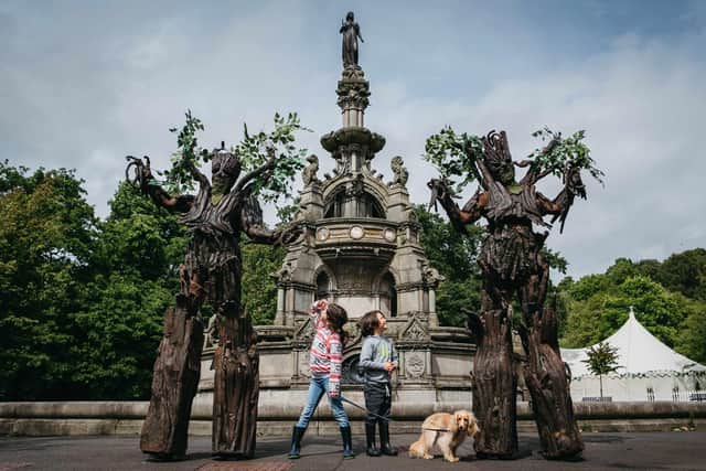 Clem Sheridan (8) and Sholto Sheridan (6) were entertained by street theatre act Treemendous on the first day of the Dandelion Festival in Glasgow. Picture: Andrew Cawley