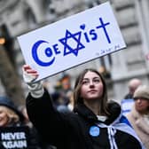 A protester holds reading "Coexist" during a demonstration in central London on Sunday to protest against antisemitism. Photo by JUSTIN TALLIS / AFP