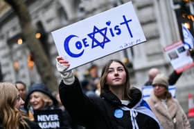 A protester holds reading "Coexist" during a demonstration in central London on Sunday to protest against antisemitism. Photo by JUSTIN TALLIS / AFP